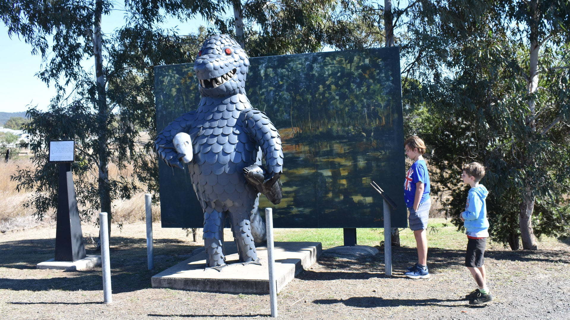 Sculpture of a bunyip in front of a mural, at the Bunyip Statue in Mulgildie