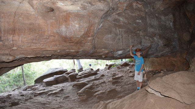 Inside a cave looking outward of a low entrance, at the Bloodwood Cave at Cania Gorge