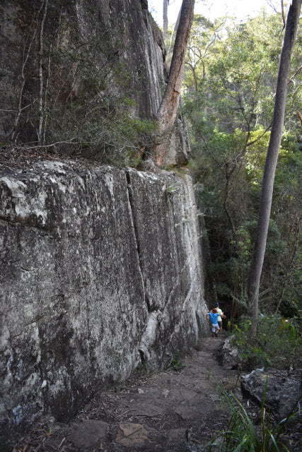 Rock wall on the left with rock stairs down the side of it, at the end of the walk to The Overhang at Cania Gorge