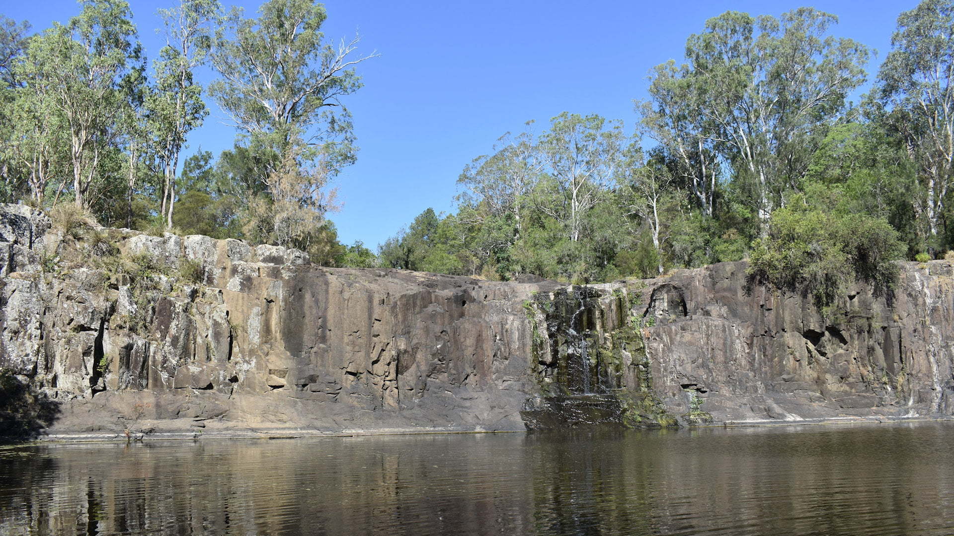 Tooloom Falls at the waterhole below the falls, during a dry period with small water flow, a free camping location near Urbanville in New South Wales