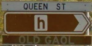 Brown sign for Old Gaol, white sign for Queen St