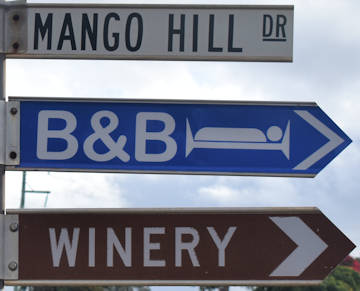 Brown sign for winery, blue sign B&B, and white sign Mango Hill Dr