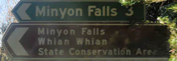 Brown sign for Minyon Falls, brown sign for Whian Whian State Conservation Area, green sign for Minyon Falls 3km