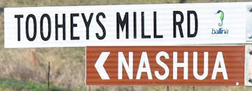 Brown sign for Nashua, white sign for Tooheys Mill Rd