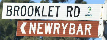 Brown sign for Newrybar, white sign for Brookley Rd